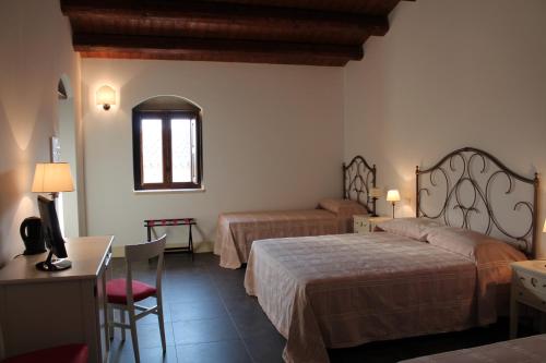 a hotel room with two beds and a table at Tenuta Zannafondo in Donnafugata