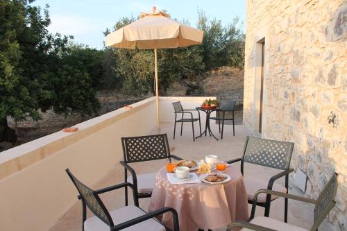 a table and chairs with an umbrella on a patio at Tenuta Zannafondo in Donnafugata