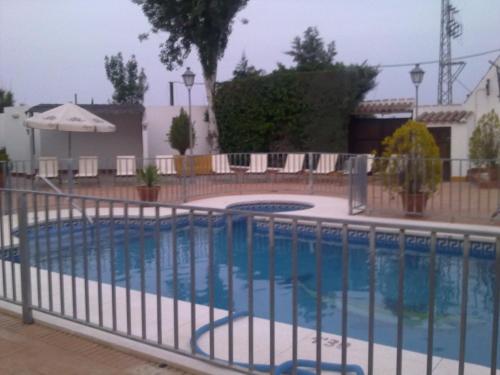 a swimming pool with a fence around it at Posada de Jose Mª El Tempranillo in Alameda