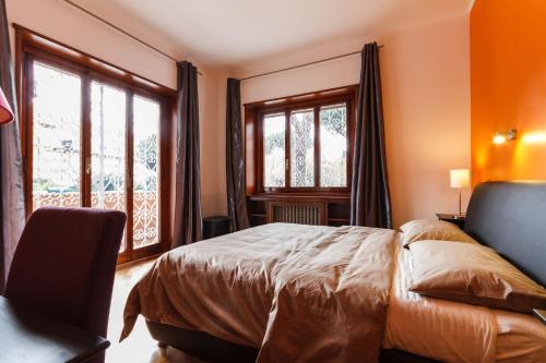 a bedroom with a bed and two windows at L'Angolo Cortese in Rome