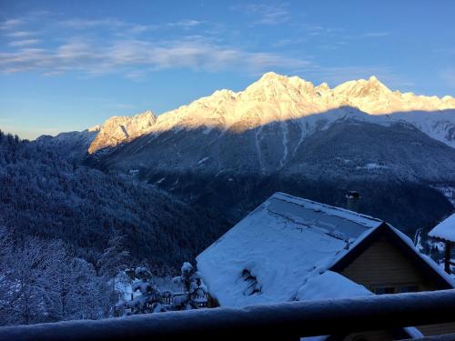 a snow covered mountain with a house in the foreground at Les Ecureuils Squirrel Lodge in Oz