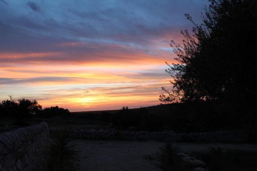 a sunset with the sun setting in the sky at Tenuta Zannafondo in Donnafugata