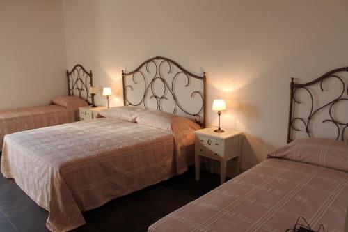 a hotel room with two beds and two lamps at Tenuta Zannafondo in Donnafugata