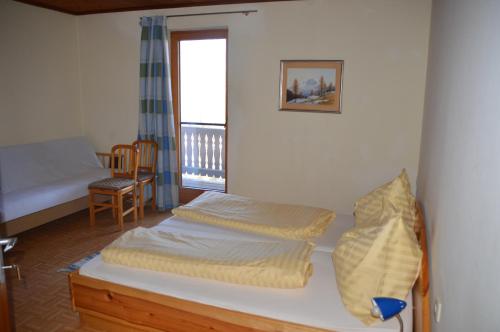 a bedroom with two beds and a table and a window at Gasthof Johannesmesner in Sankt Paul im Lavanttal