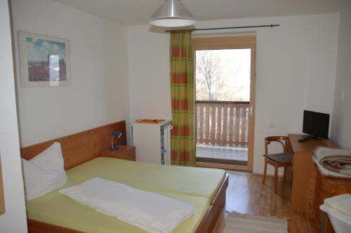 Schlafzimmer mit einem Bett, einem Schreibtisch und einem Fenster in der Unterkunft Gasthof Johannesmesner in Sankt Paul im Lavanttal