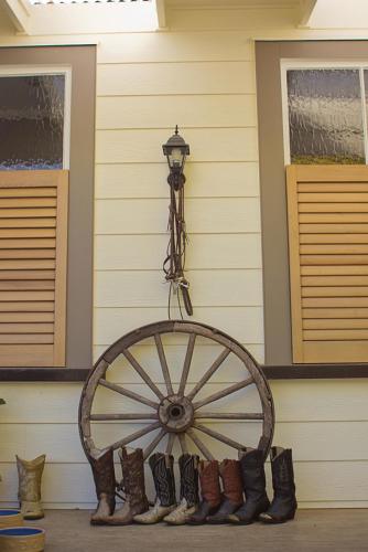 a woodenokedoked wheel with a group of boots against a wall at Cambridge Coach House in Cambridge