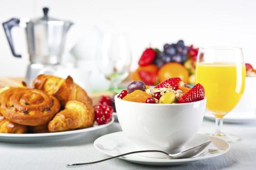 a table with a bowl of fruit and a cup of orange juice at Podere Il Pino in Poggibonsi