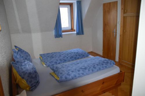 a bedroom with two beds with blue sheets and a window at Gasthof Johannesmesner in Sankt Paul im Lavanttal