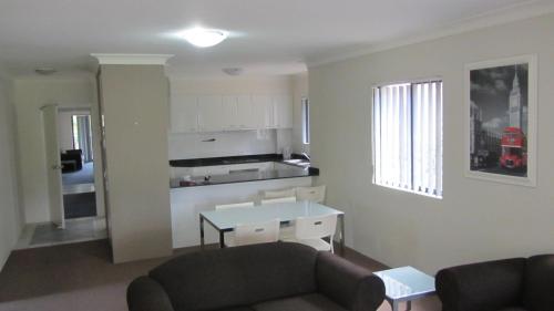 a living room with a couch and a table at Parkside Apartments Parramatta in Sydney