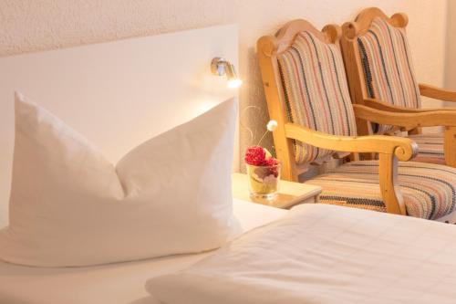 a bedroom with a bed and a rocking chair at Akzenthaus Alpenrose Nesselwang in Nesselwang