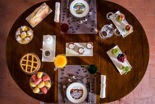 a wooden table with breakfast foods on it at Callegherie 21 Boutique B&B in Imola