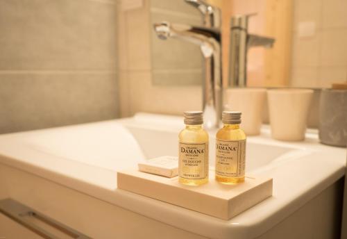 two bottles of essential oils sitting on a bathroom sink at La ferme des Colieuvres in Lièpvre