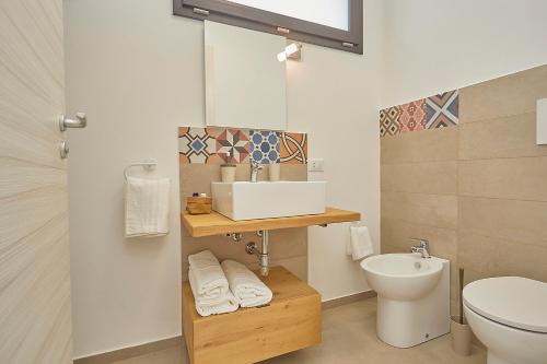a bathroom with a sink and a toilet at Villa Vo' Scurá in Alcamo Marina