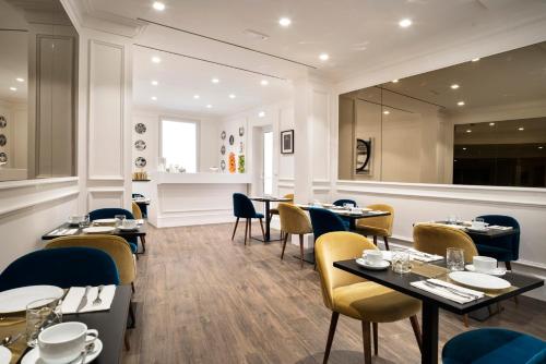 a restaurant with tables and chairs and a mirror at The Shire Hotel in Rome