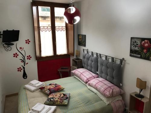 a bedroom with a bed with pink pillows on it at Casa Mojito o Chupito in Sassari