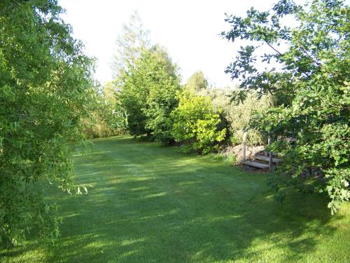 a green yard with trees and a field of grass at Longbourne Lodge Motel Mosgiel in Mosgiel