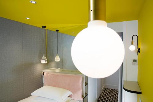 a bathroom with a yellow ceiling and a light fixture at Hotel Haussmann Saint Augustin in Paris