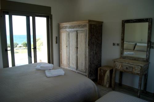 a bedroom with a bed with a mirror and a dresser at Manna Gea in Vonitsa