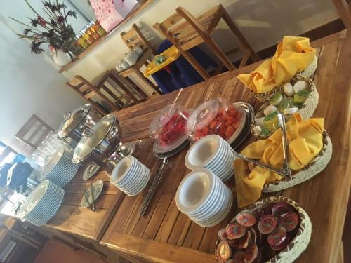 a wooden table topped with plates and bowls of food at Awa De Mar Hotel Tolu in Tolú