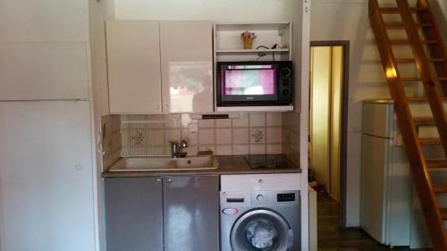 uma cozinha com uma máquina de lavar roupa e um micro-ondas em Résidence Cap Azur Appartement 217 em Villeneuve-Loubet