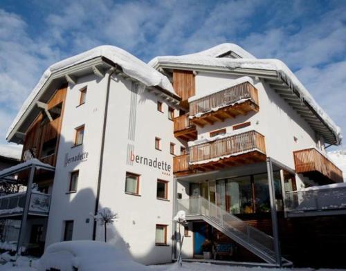 a large building with snow on the roof at Hotel Garni Bernadette in Serfaus