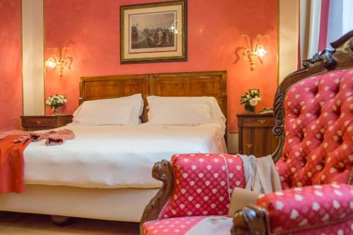 
a hotel room with a bed, chair and a lamp at Due Torri Hotel in Verona
