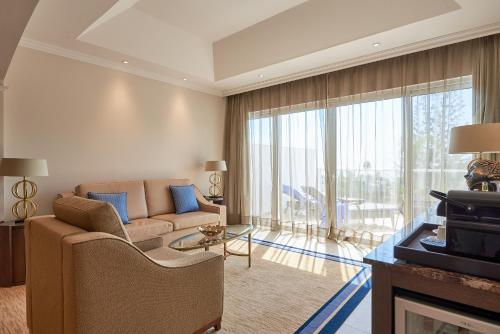 a living room with a couch and a fireplace at Dona Filipa Hotel in Vale do Lobo