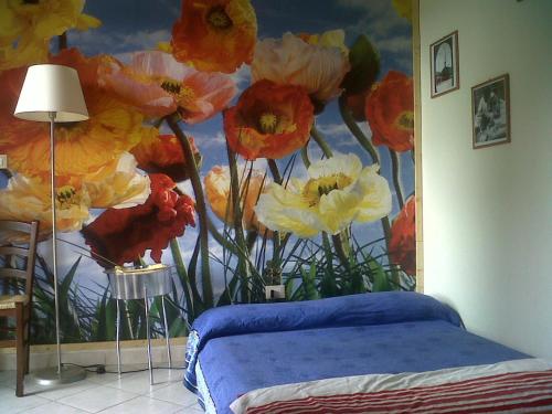 a bedroom with a painting of flowers on the wall at La Casa di Ulisse B&B in Quercianella