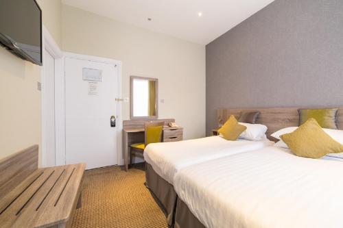a hotel room with two beds and a television at Phoenix Hotel in London