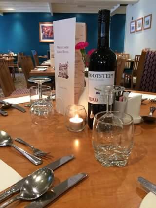 a bottle of wine and a candle on a table at Wheatlands Lodge Hotel in York