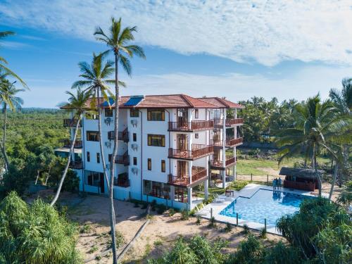 an aerial view of a resort with a swimming pool and palm trees at Ananya Beach Resort in Tangalle