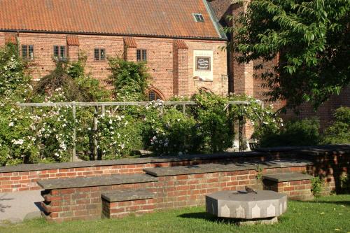 a brick retaining wall with a bench in a yard at Ystad Camping in Ystad