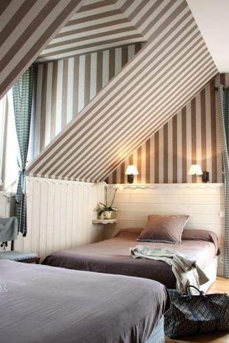 a bedroom with two beds and a striped wall at Villa Bon Repos in Argelès-Gazost