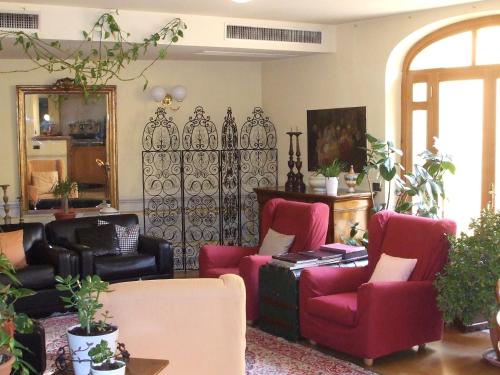 a living room with red chairs and a mirror at Hotel San Luca in Spoleto