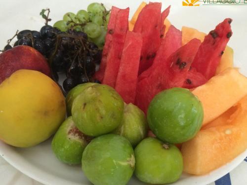 a plate of fruit and vegetables on a plate at Villaggio Elisena in Vieste