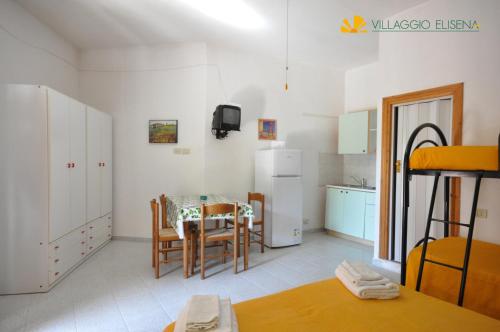a kitchen and dining room with a table and chairs at Villaggio Elisena in Vieste