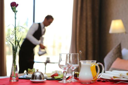 a table with wine glasses and a man in a room at Terminus City Center Oujda in Oujda