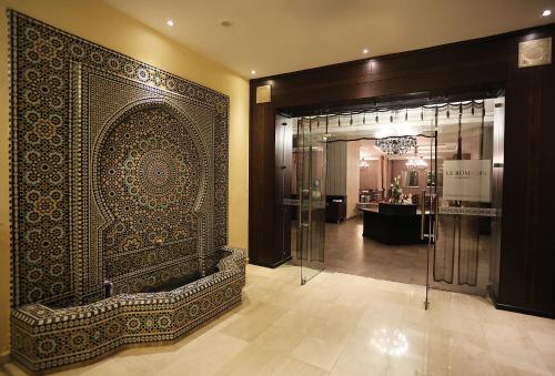 baño con ducha y pared de mosaico en Terminus City Center Oujda en Oujda