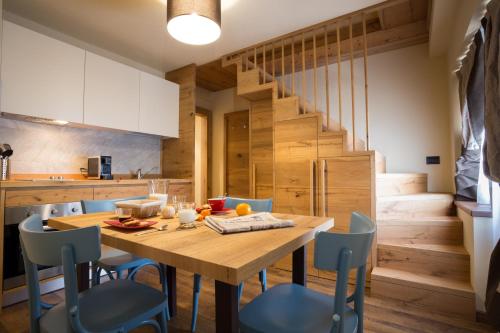 a kitchen and dining room with a wooden table and chairs at Maison Fosson in Champoluc