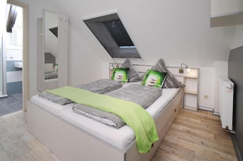 a bedroom with a bed with a green blanket on it at Gutshof Zum Adlernest in Arnsnesta