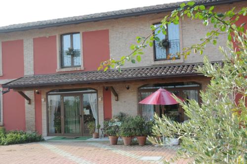 a house with a red and white at Agriturismo La Fattoria Del Boschetto in Fontanellato