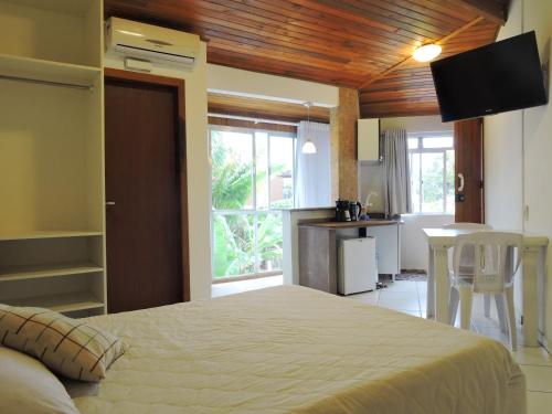 1 dormitorio con 1 cama y cocina con mesa en Pousada Pedra Rosa, en Florianópolis