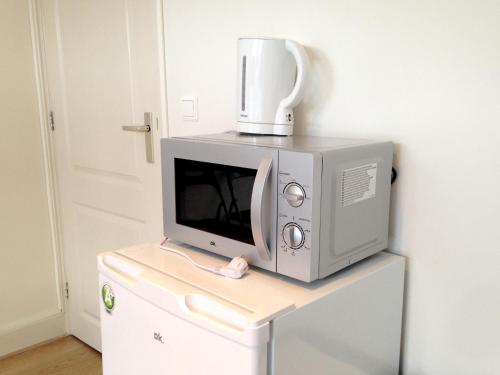 a microwave oven sitting on top of a white cabinet at Bnbrose in Amsterdam