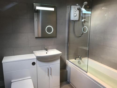 een badkamer met een toilet, een wastafel en een douche bij Apartment 5, Cornerhouse Apartments in Llandudno