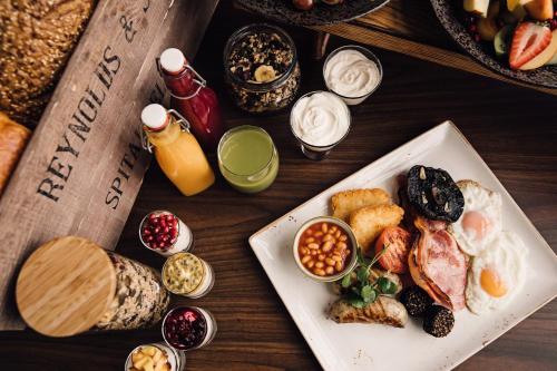 a table with a plate of breakfast foods and condiments at Woodland Grange in Leamington Spa