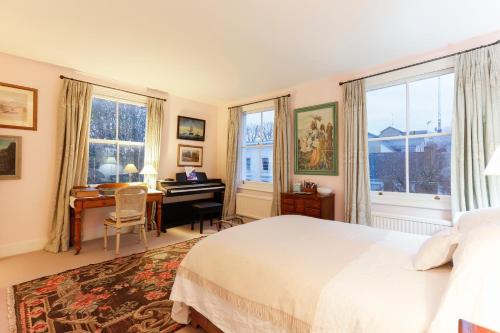 ロンドンにあるAttractive Chelsea apartment sleeps 4のベッドルーム1室(ベッド1台、ピアノ付きデスク付)