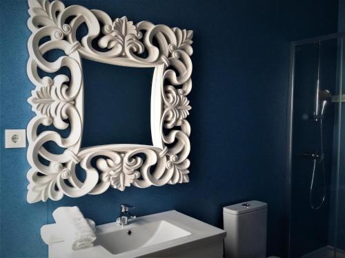 a bathroom with a white mirror and a sink at Ansiturismo Alojamento in Ansião