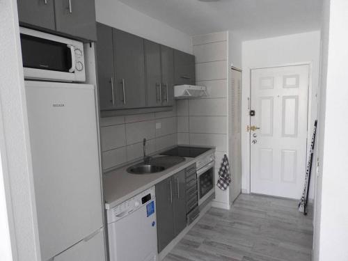 a small kitchen with a sink and a microwave at castle harbour in Los Cristianos