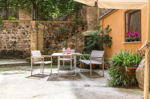 ローマにあるSantonofrio Apartmentsのパティオ(テーブル、椅子、パラソル付)