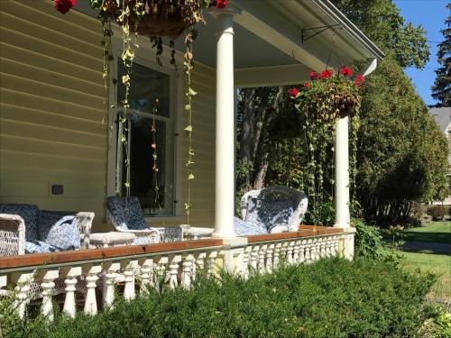 a porch with wicker chairs on a house at Cooperstown Bed and Breakfast in Cooperstown